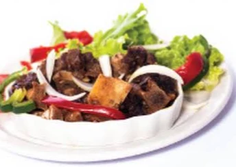 Viande en sauce avec oignons et salade