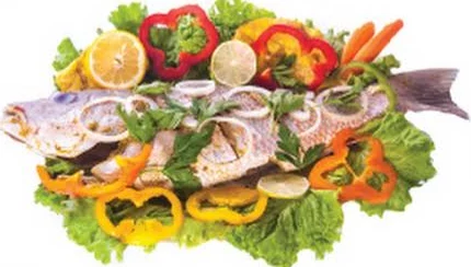 Poisson entier sur lit de laitue, poivrons et citron